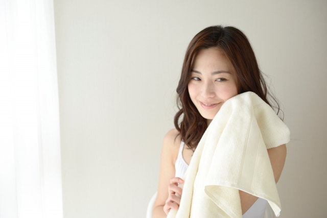 タオルで肌をこすらず優しく押さえて水分をとる女性