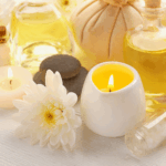 キャンドルとアロマオイル、白い花が並ぶ落ち着いた雰囲気のスキンケアシーン。大人の女性のための癒しと上質さを感じさせるイメージ。
