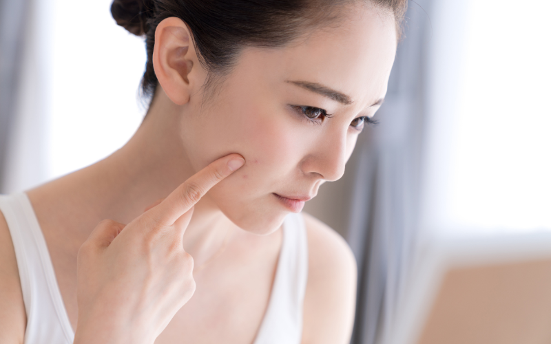 「40代女性が紫外線による肌老化を気にして鏡を見る様子