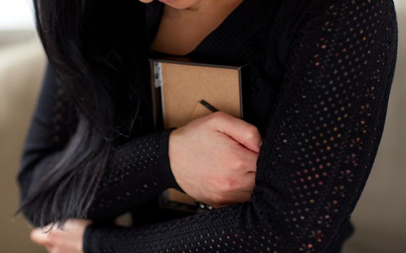 遺影を抱きしめている女性の画像