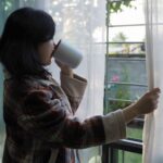 窓辺で静かに過ごす女性。人との距離を大切にしながら心を整える時間