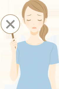 バツの札を片手に持った女性。残念な表情をしている。