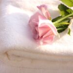 日常を丁寧に扱うことが美しさにつながることを象徴する、白いタオルと花